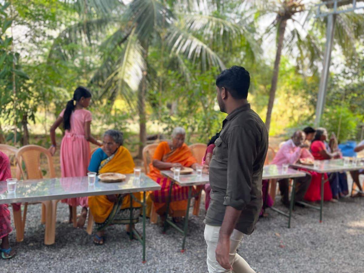 Elderly women being cared for at an outdoor community meal